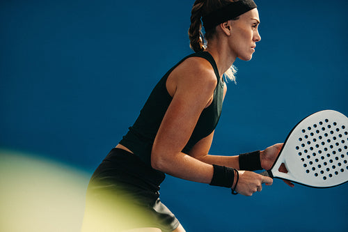 Woman getting ready to play on padel court with her racket in hand