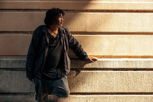 Homeless man looking away thoughtfully outdoors