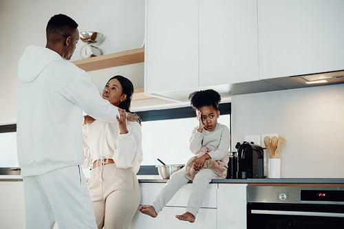 Shy little girl looks away while her parents share a romantic moment