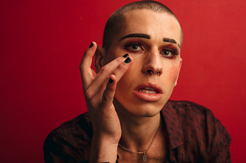 Transgender male applying make up