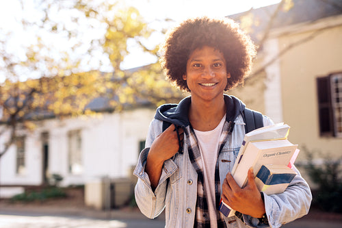 College student with lots of books in college campus