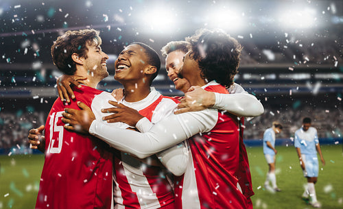 Football players celebrating a victorious match in a professional football stadium