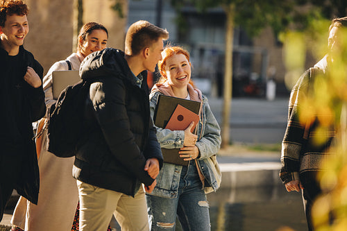 Smiling girl walking with friends in high school