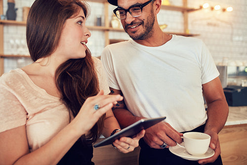 Young couple at cafe counter having discussion