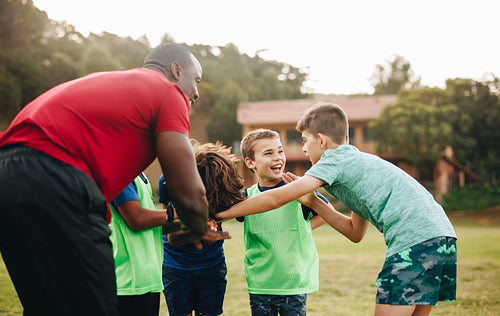 School sports team having a huddle in a rugby field