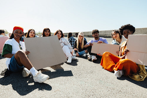 Young diverse protest group outdoors holding blank cardboard signs