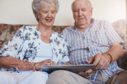 Happy senior couple using digital tablet
