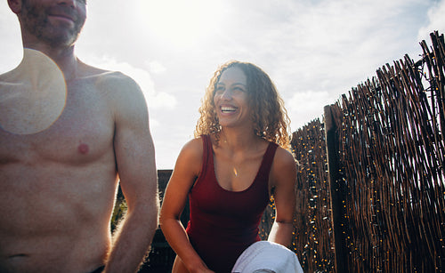 Woman holding towel outdoors before a cold plunge with a friend on a sunny day