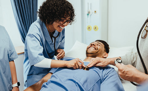 Doctor in training: Female medical student using stethoscope on her peer in hospital