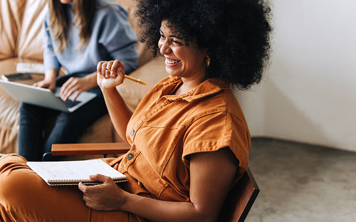 Happy black businesswoman smiling in an office lobby