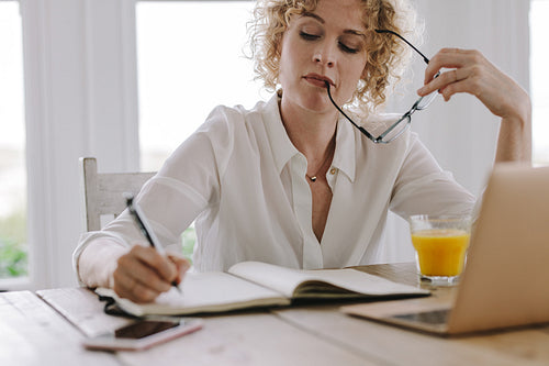 Woman working on laptop sitting at home