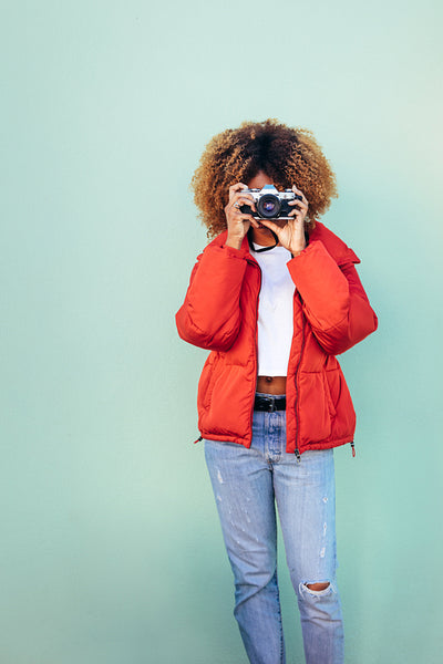 Woman holding a camera to her face taking a photo