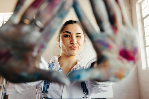 Carefree young painter making a frame with her hands