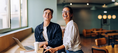 Happy colleagues enjoying a break and smiling in a casual workplace setting