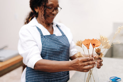 Mature woman selling floral handicraft in her shop