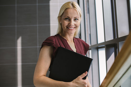 Smiling businesswoman with a file in office