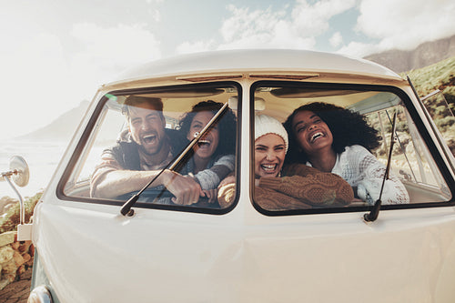 Friends on roadtrip sitting inside van