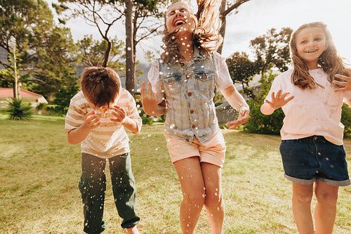 Children enjoying summer outdoor fun playing together with water splashes and laughter
