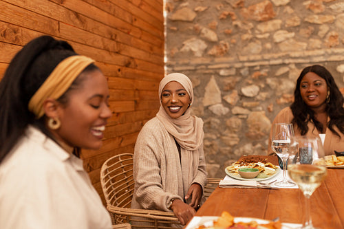 Multicultural female friends chatting in a restaurant