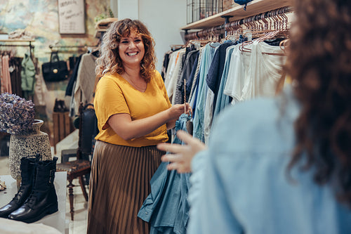 Clothing store owner assisting customer in her store