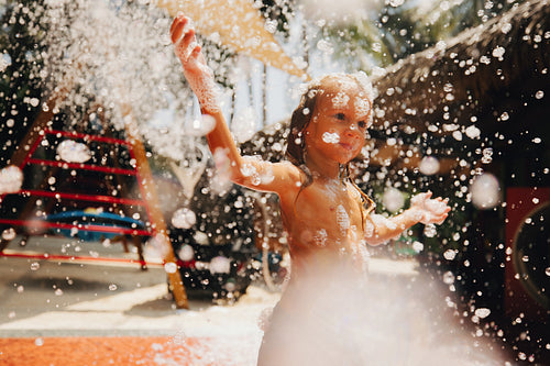 Young boy enjoying a fun summer day playing with bubbles in the sun