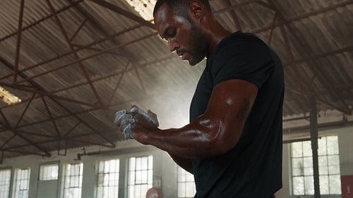 Fit man applying chalk powder on hands in gym