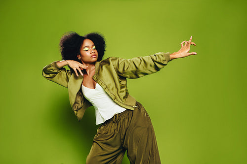 Portrait of a woman captures identity and movement in a confident green studio scene