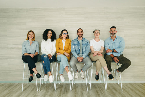 Cheerful job applicants sitting together in a row