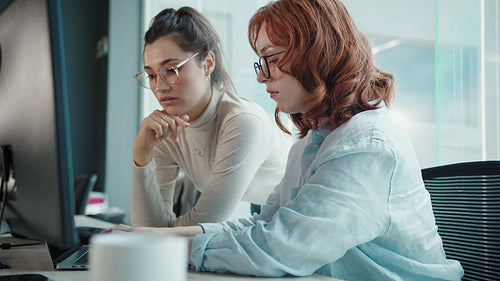 Female software engineers working on a computer in a tech company