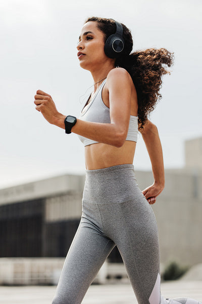 Athletic woman running through the city