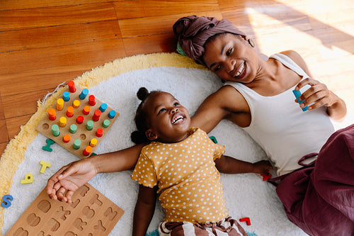 Mother and child playtime on rug with blocks