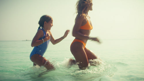 Joyful mother and daughter enjoy an idyllic tropical family vacation at a luxurious resort