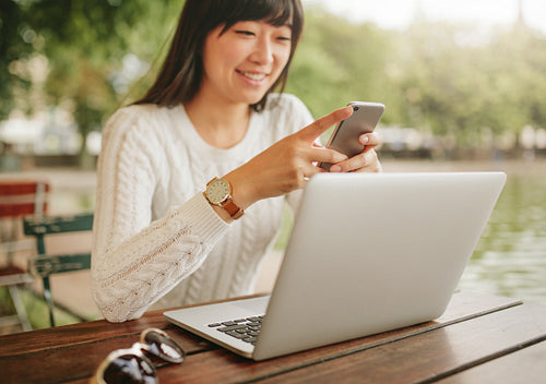 Female at outdoor cafe using mobile phone