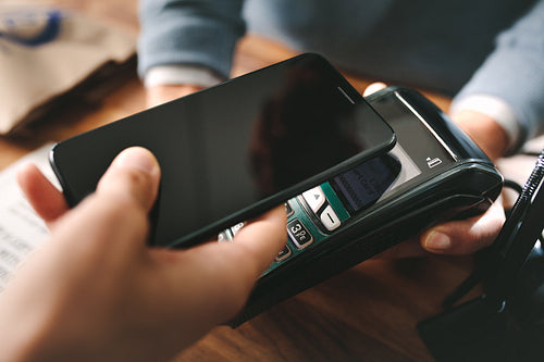 Customer paying through smartphone using NFC technology