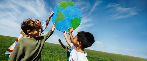 Children learning about the world with globe outdoors