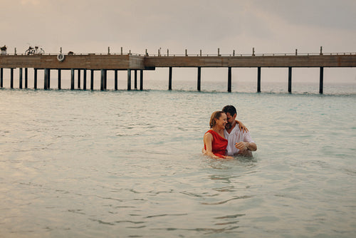 Lovely couple embracing in the sea during a luxurious tropical holiday