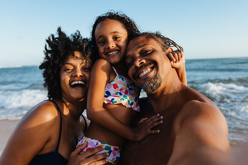 Happy family taking a selfie on the beach during vacation