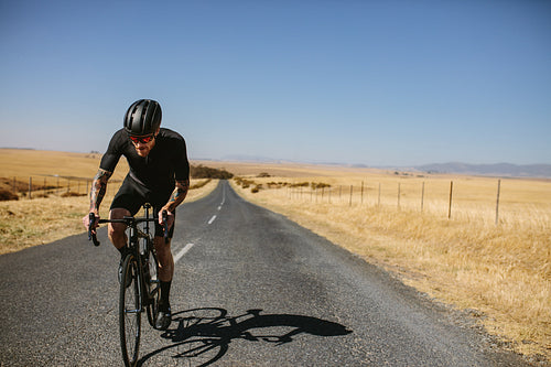  Professional male biker on country highway