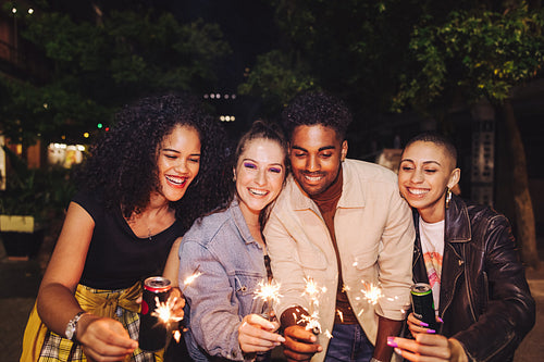 Friends celebrating with bengal lights at night