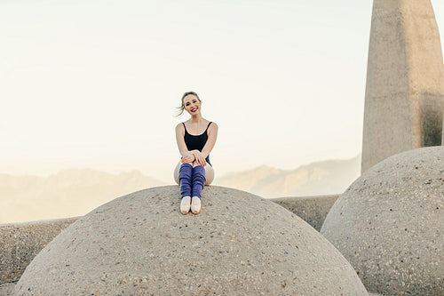 Female ballet dancer sitting near a monument