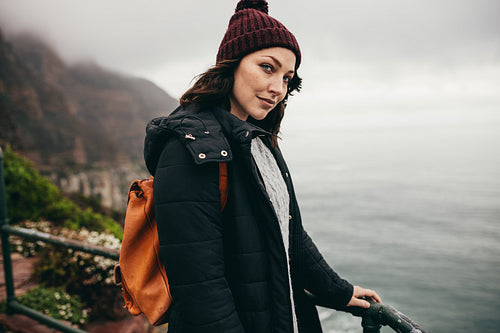 Beautiful woman standing by a railing at viewpoint