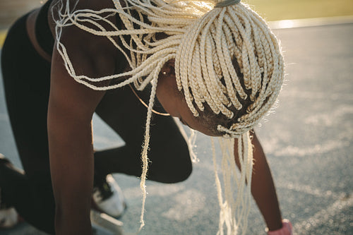 Sprinter using a starting block to start her sprint on a running track