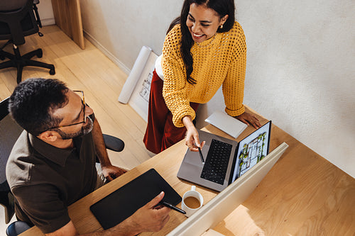 Two architects discussing a project design at an office workspace in collaboration