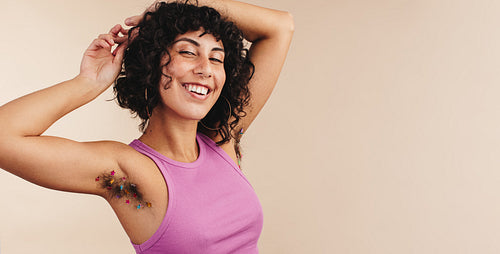 Cheerful young woman showing off her unshaven underarms