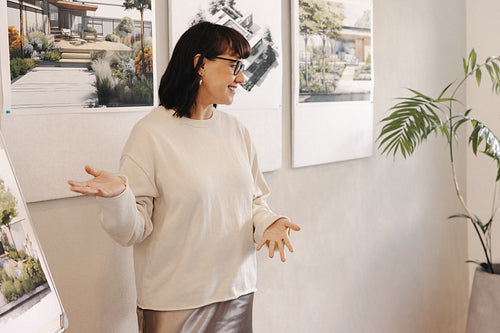 Female businesswoman presenting architectural designs in a creative professional setting