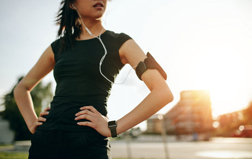 Young woman taking a break while on morning run