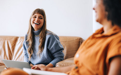 Happy young businesswoman laughing with her colleague in an office