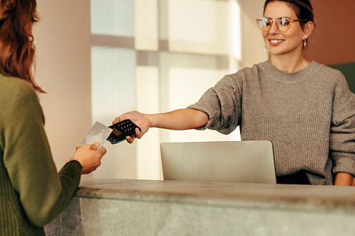 Shop assistant taking a card payment from a female customer