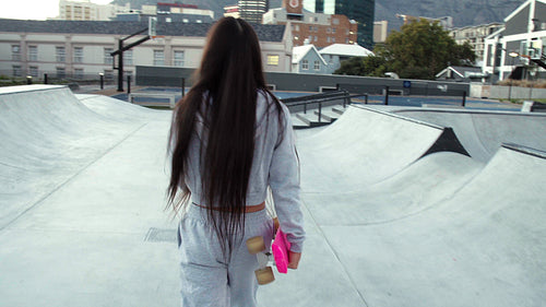Happy young woman skating in an urban skate park