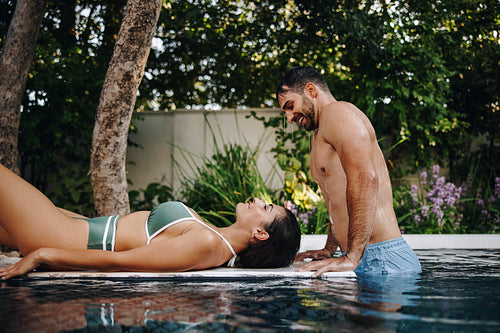 Playful couple at a luxury swimming pool